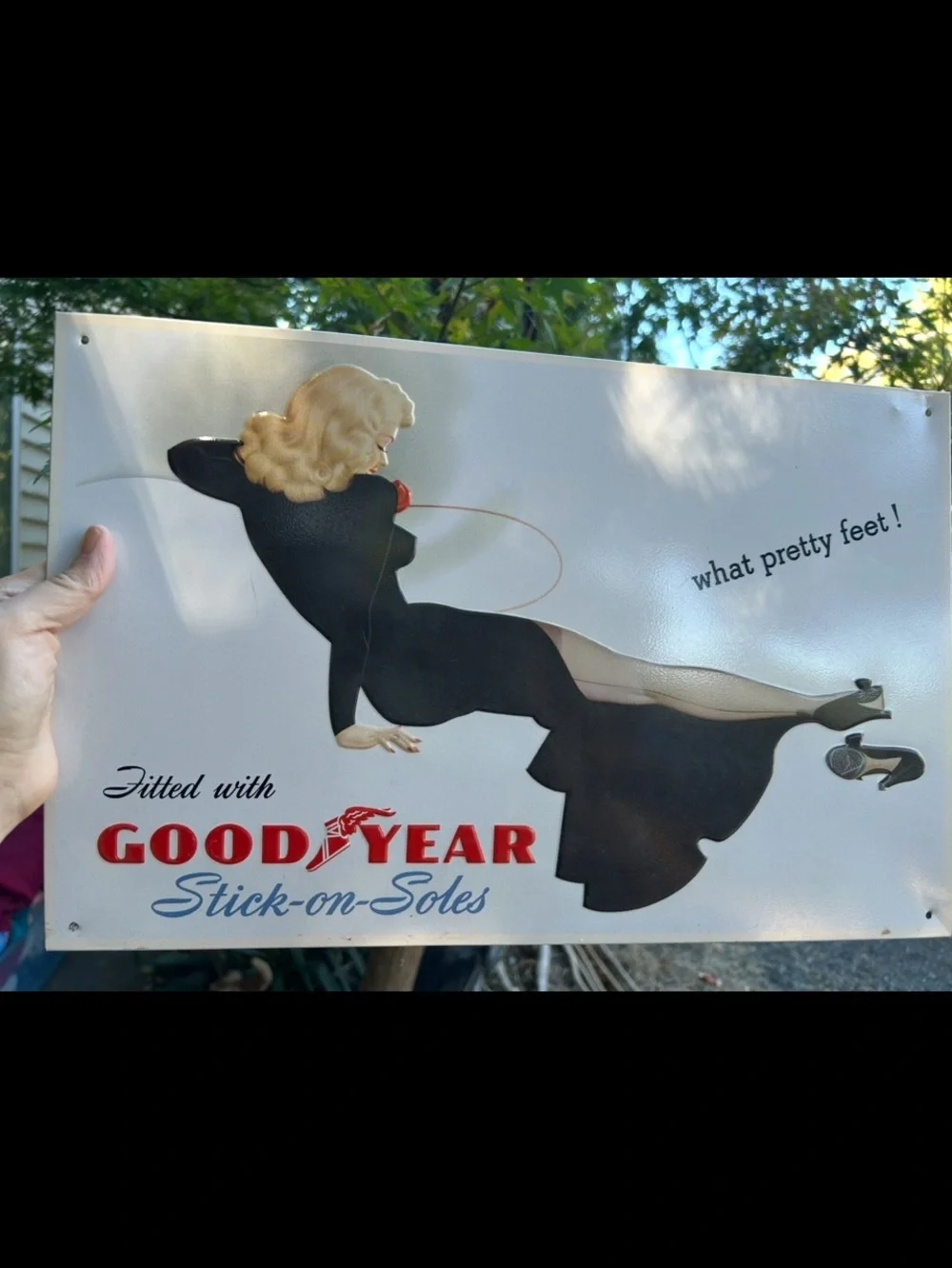 Vintage-style metal sign features a retro advertisement for Goodyear